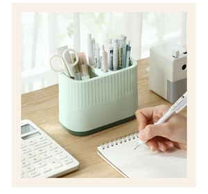 Close-up of light green desk organizer with vertical stripes and divided compartments