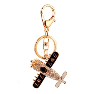 Golden fighter jet keychain with clear rhinestones and black enamel star wings