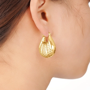Boucles d'oreilles gouttes dorées avec texture maillée portées par un mannequin