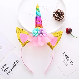 Detail eines Einhorn-Haarreifens mit Regenbogenhorn, goldenen Ohren und rosa Stoffblumen