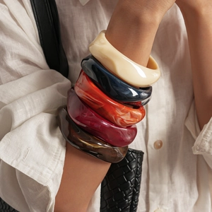 Gros plan de bracelets torsadés en acrylique vintage empilés aux motifs marbrés sur un mannequin