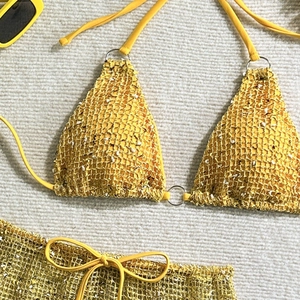 Detailed macro view of yellow crochet bikini with beads and metal ring connectors