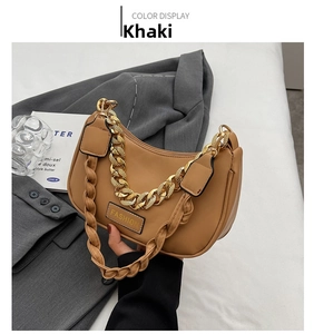 Close-up of khaki crescent bag featuring gold chain strap and fashion label detail