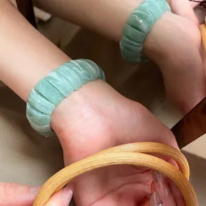 Elegant green resin stretch bracelet with marble texture in a minimalist mirrored display