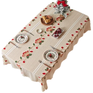 Beige Christmas tablecloth with embroidered bells, holly berries, and white lace borders