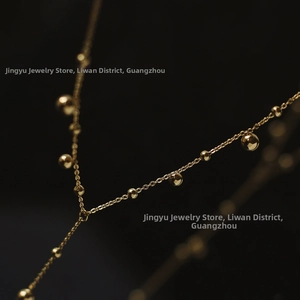 Detailed macro view of 18K gold plated Y-shaped tassel necklace with polished beads