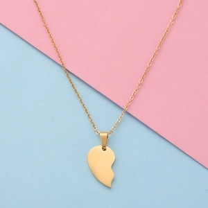 Macro detail of half heart pendant in gold polished steel with fine O-chain link