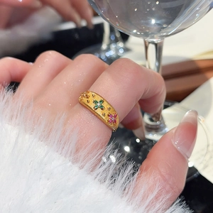 Detail of 24k gold plated flower ring with brushed texture and colorful zircons