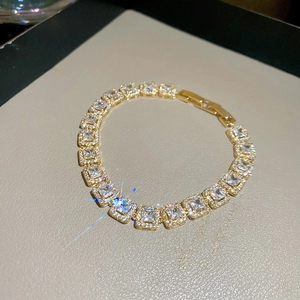 Bracelet tennis doré avec oxydes de zirconium carrés et fermoir sécurisé en gros plan