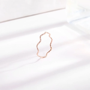 Minimalist wave-shaped titanium steel ring in rose gold finish on white background