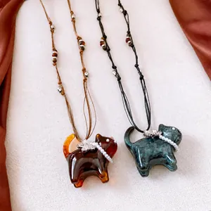 Handmade resin cat pendant necklace featuring pearl collar and metal flower charm on cord