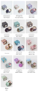 Macro shot of 13 aromatic soy wax candles with dried flowers in colorful tin boxes