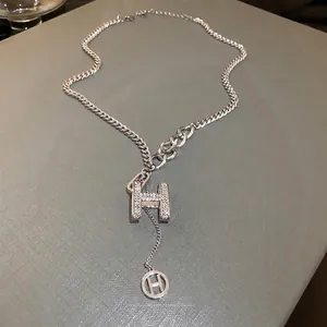 Silver tone spliced chain necklace with pavé diamond H pendant and small ring charm