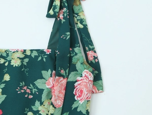 Detail of vintage floral print dress featuring pink roses and bow-tie shoulder straps