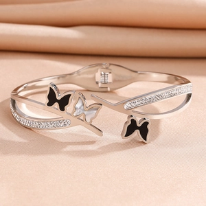 Detail of silver titanium steel bracelet with three butterfly motifs and shiny zircons