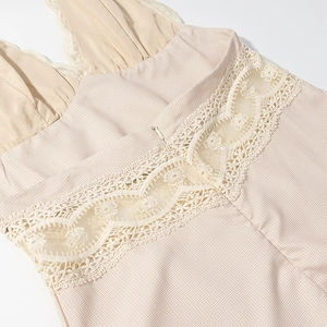 Détail de robe beige montrant la texture à carreaux, la dentelle et le zip invisible
