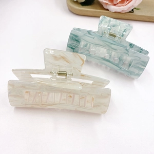 Vintage acrylic hair claws with marble pattern in beige and teal on white background