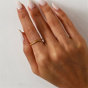 Detail showing wavy minimalist 14K gold plated stainless steel ring on finger