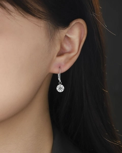 Macro detail of silver S925 lever-back earrings with a brilliant round-cut diamond on a model
