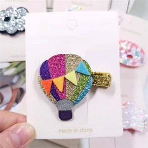 Detail of glitter hot air balloon hair clip with colorful sequins on display card