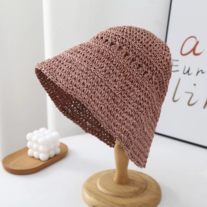 Detail of handwoven texture on a foldable straw bucket hat in dusty pink color