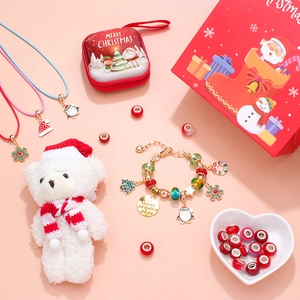 Coffret bijoux Noël DIY avec perles, breloques et pochette rouge sur fond rose