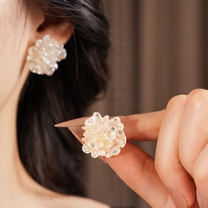 Détails de boucles d'oreilles fleur aux pétales translucides et strass étincelants