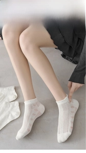 Macro detail of white ballet style lace ankle socks with breathable mesh and bow design