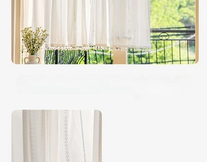 Detailed close-up of white sheer curtain with lace stripes and plush ball trim decor