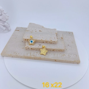 Detailed view of star-shaped evil eye pendant with white enamel and golden plating