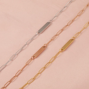 Detailed view of paperclip necklaces with bar pendants in silver, gold, and rose gold
