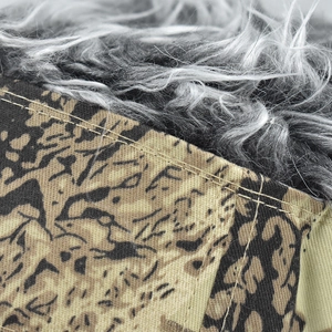 Macro shot of double-stitched camouflage canvas and soft faux fur lining details