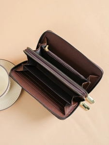 Brown checkered long wallet with double zipper and multiple card slots in flat lay view