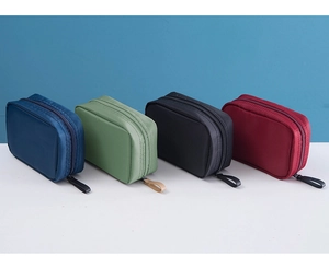 Quatre trousses à maquillage en nylon bleu, vert, noir et rouge avec fermeture éclair