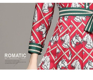 Détail d'une robe vintage rouge avec imprimés chevaux et ceinture rayée verte