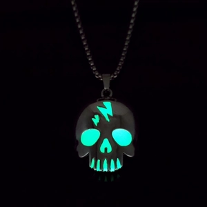 Detailed view of skull pendant with glowing green lightning pattern in dark