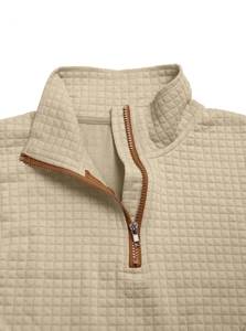 Detailed view of beige quilted sweatshirt fabric featuring a half-zip metal neckline