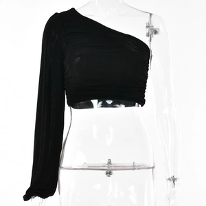 Vue détaillée du crop top noir à une épaule avec manches longues et tissu plissé