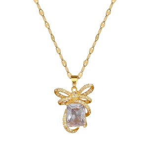 Luxury gold titanium necklace with sparkling crystal bow pendant on a clean white background