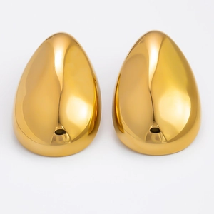 Detailed macro view of gold teardrop earrings with high-polish metallic mirror finish