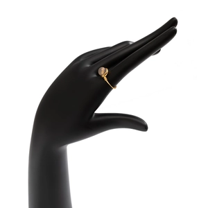 Detail of handmade gold wire-wrapped ring with a translucent natural stone on model