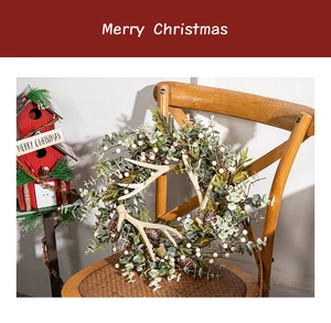 Christmas wreath with reindeer antlers, pine cones and berries on a vintage wooden chair