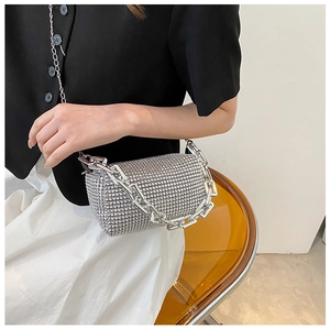 Close-up of silver rhinestone cylinder handbag with thick metal chain strap and handle