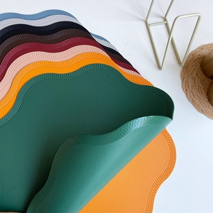 Faux leather flower placemats with wavy edges shown in multiple stacked colors