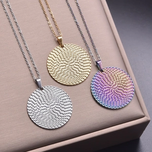 Detailed view of round textured pendants in silver, gold, and rainbow finishes