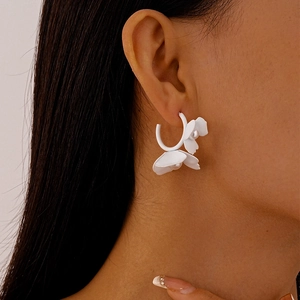 Elegant white floral C-shaped earrings with pearls shown on a model for a summer look
