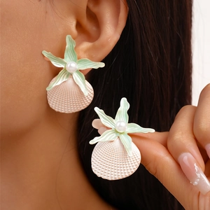 Detail showing a pink shell and mint green starfish earring with a centered white pearl