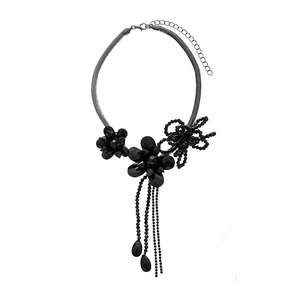 Dark floral statement necklace with faceted beads and tassel drops on a white background