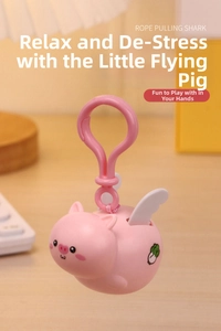 Close-up of pink flying pig stress relief toy with pull-string on warm wooden table