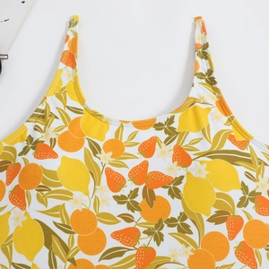 Detail view of one-piece swimsuit featuring vibrant tropical fruit and lemon prints